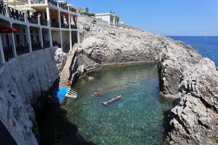 La piscina naturale del Lido Caicco, chiusa fra la scogliera e lo stabilimento con la scala a mare.