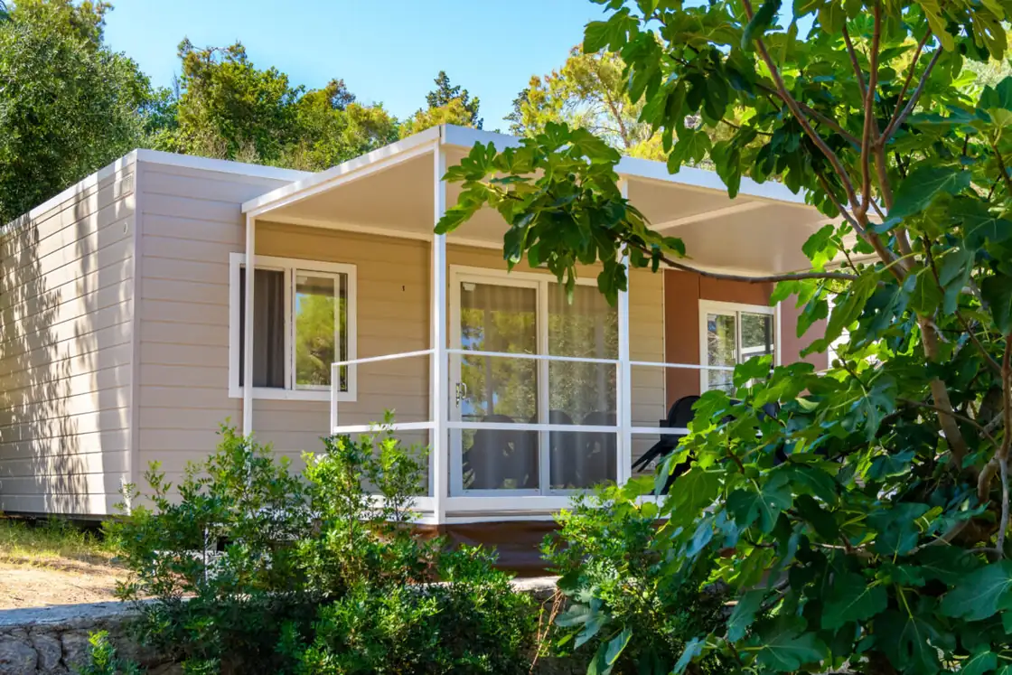 La mobile home Diamond con la veranda bianca, tra il verde della pineta