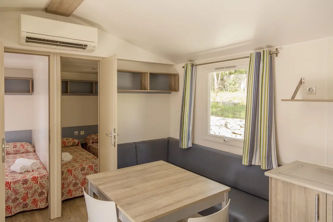 Il soggiorno della mobile home Maxi, con divano, tavolo e cucina